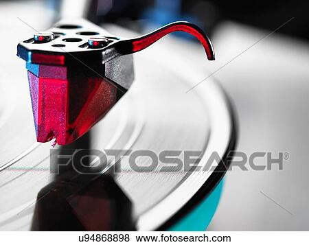 Close up of red turntable stylus playing a vinyl record View Large Photo Image Stock Photo - Close up of red turntable stylus playing a vinyl record. Fotosearch