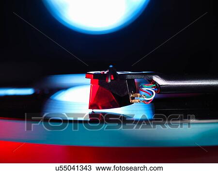 Close up of spot lit turntable and red stylus playing a vinyl record View Large Photo Image Stock Image - Close up of spot lit turntable and red stylus playing a vinyl record. Fotosearch