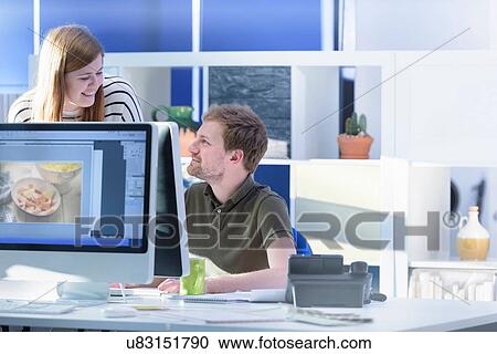 Stock Image - Colleagues working in design studio in food packaging printing factory. Fotosearch