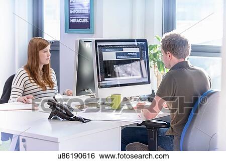 Stock Photograph - Colleagues working in design studio in food packaging printing factory. Fotosearch