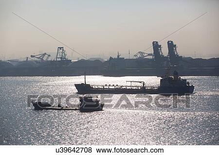 Stock Photo - Container ships, cranes and containers at port in background. Fotosearch