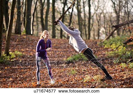 Couple in forest using resistance band View Large Photo Image Stock Photo - Couple in forest using resistance band. Fotosearch