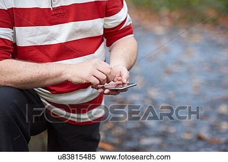 Cropped shot of male runner using touchscreen on smartphone in forest View Large Photo Image Stock Photography - Cropped shot of male runner using touchscreen on smartphone in forest. Fotosearch