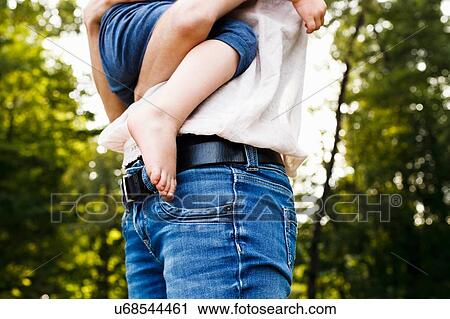 Cropped shot of mid adult woman carrying daughter in park View Large Photo Image Stock Image - Cropped shot of mid adult woman carrying daughter in park. Fotosearch
