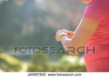 Cropped side view of mature woman checking wrist watch View Large Photo Image Stock Image - Cropped side view of mature woman checking wrist watch. Fotosearch