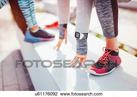 Cropped view of female runners warming up in city View Large Photo Image Stock Image - Cropped view of female runners warming up in city. Fotosearch