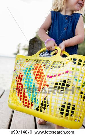 Cropped view of female toddler carrying yellow basket on wooden pier, Lake Starnberg, Bavaria, Germany View Large Photo Image Stock Image - Cropped view of female toddler carrying yellow basket on wooden pier, Lake Starnberg, Bavaria, Germany. Fotosearch