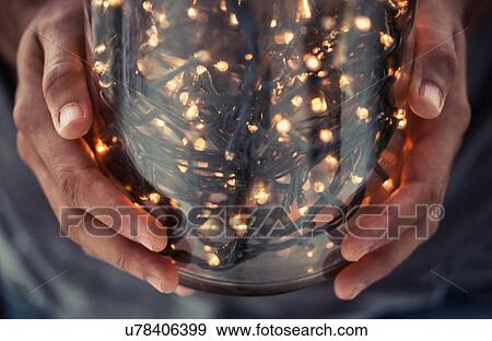 Cropped view of hands holding glass jar filled with decorative lights View Large Photo Image Stock Photo - Cropped view of hands holding glass jar filled with decorative lights. Fotosearch