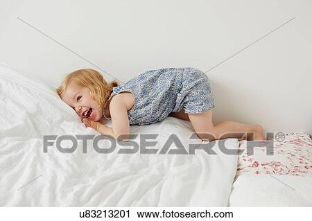 Cute female toddler playing on bed View Large Photo Image Stock Image - Cute female toddler playing on bed. Fotosearch