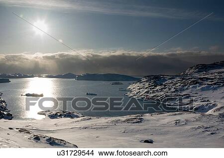 Elevated sunlit view of Ilulissat icefjord, Disko Bay, Greenland View Large Photo Image Picture - Elevated sunlit view of Ilulissat icefjord, Disko Bay, Greenland. Fotosearch