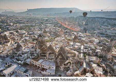 Elevated view of hot air balloons over rock formations and dwellings, Cappadocia, Anatolia, Turkey View Large Photo Image Stock Photo - Elevated view of hot air balloons over rock formations and dwellings, Cappadocia, Anatolia, Turkey. Fotosearch