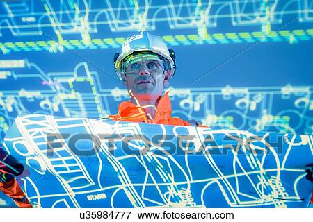 Engineer with blueprint and projected plans View Large Photo Image Stock Photo - Engineer with blueprint and projected plans. Fotosearch