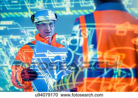 Stock Image - Engineers with blueprints and projected plans. Fotosearch