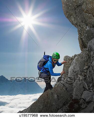 Stock Photo - Female climber on rocky wall at sunset, Mont Blanc, France. Fotosearch