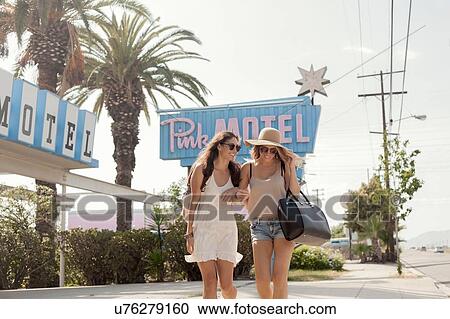 Female friends walking past motel, Los Angeles, California, USA View Large Photo Image Stock Image - Female friends walking past motel, Los Angeles, California, USA. Fotosearch
