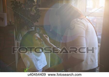 Stock Photo - Female make up artist applying eye pencil to clients eyelid. Fotosearch