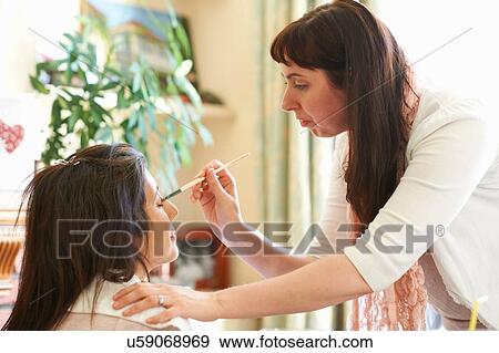 Female make up artist applying eye shadow to clients eyelid View Large Photo Image Stock Photo - Female make up artist applying eye shadow to clients eyelid. Fotosearch