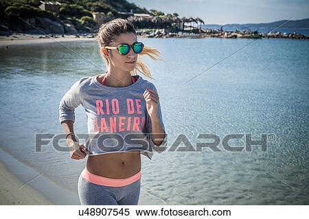 Stock Photography - Female runner running on beach, Villasimius, Sardinia, Italy. Fotosearch