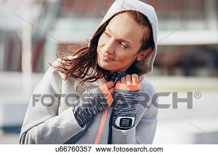 Female runner zipping up hoody in city View Large Photo Image Stock Photo - Female runner zipping up hoody in city. Fotosearch