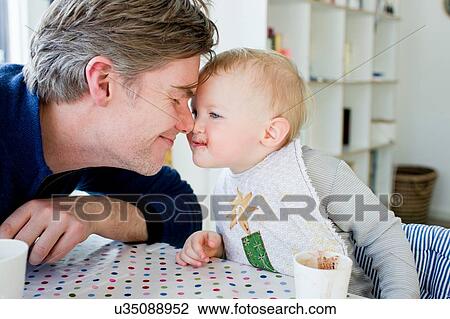 Female toddler and father face to face at kitchen table View Large Photo Image Stock Image - Female toddler and father face to face at kitchen table. Fotosearch