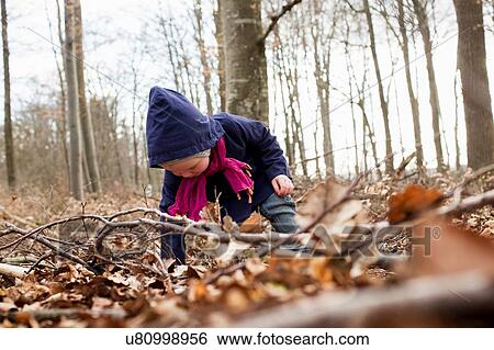 Female toddler bending forward to play with autumn leaves View Large Photo Image Stock Photograph - Female toddler bending forward to play with autumn leaves. Fotosearch