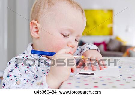 Female toddler drawing on paper at table View Large Photo Image Picture - Female toddler drawing on paper at table. Fotosearch