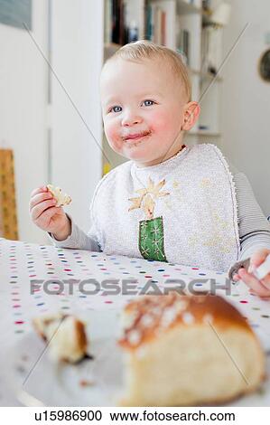 Female toddler eating bread at kitchen table View Large Photo Image Stock Image - Female toddler eating bread at kitchen table. Fotosearch