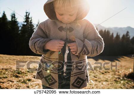 Female toddler fastening hooded jacket, Tegernsee, Bavaria, Germany View Large Photo Image Stock Photography - Female toddler fastening hooded jacket, Tegernsee, Bavaria, Germany. Fotosearch
