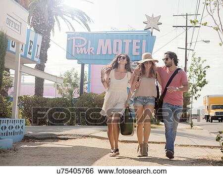 Stock Photograph - Friends walking past motel, Los Angeles, California, USA. Fotosearch