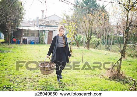 Full length front view of young woman in garden carrying wickerwork basket View Large Photo Image Stock Image - Full length front view of young woman in garden carrying wickerwork basket. Fotosearch