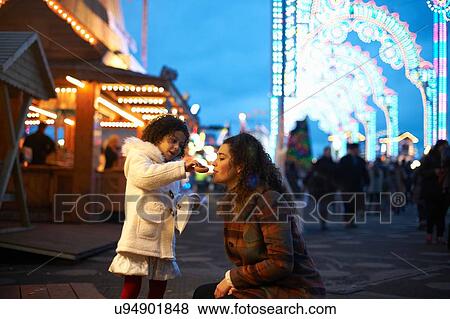 Girl at amusement park feeding mother doughnuts View Large Photo Image Stock Photo - Girl at amusement park feeding mother doughnuts. Fotosearch