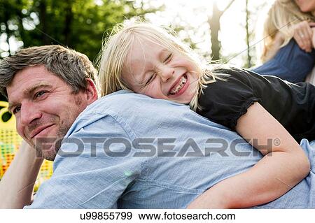 Girl hugging father in park View Large Photo Image Stock Photo - Girl hugging father in park. Fotosearch