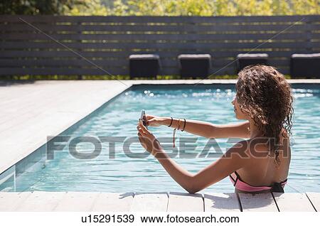 Girl in swimming pool taking smartphone selfie, Cassis, Provence, France View Large Photo Image Stock Photo - Girl in swimming pool taking smartphone selfie, Cassis, Provence, France. Fotosearch