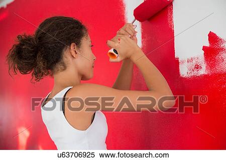 Girl painting wall red with paint roller View Large Photo Image Stock Photography - Girl painting wall red with paint roller. Fotosearch