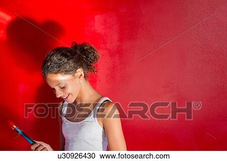 Girl painting wall red with paintbrush View Large Photo Image Stock Image - Girl painting wall red with paintbrush. Fotosearch