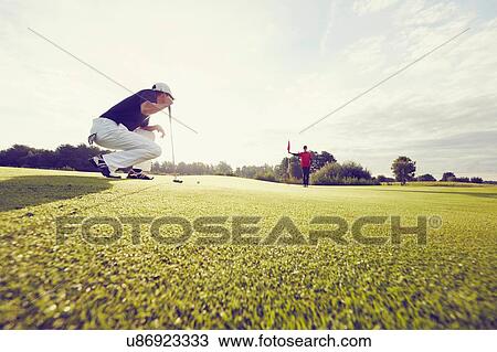 Golfer crouching on course, Korschenbroich, Dusseldorf, Germany View Large Photo Image Stock Image - Golfer crouching on course, Korschenbroich, Dusseldorf, Germany. Fotosearch