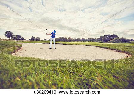 Golfer hitting ball in sand trap, Korschenbroich, Dusseldorf, Germany View Large Photo Image Stock Photo - Golfer hitting ball in sand trap, Korschenbroich, Dusseldorf, Germany. Fotosearch