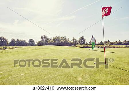 Stock Photograph - Golfer playing golf, near 14th hole, Korschenbroich, Dusseldorf, Germany. Fotosearch