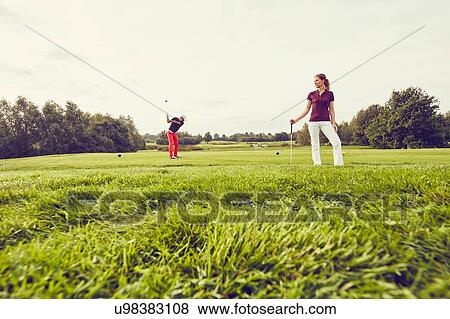 Stock Photo - Golfers playing golf on course, Korschenbroich, Dusseldorf, Germany. Fotosearch