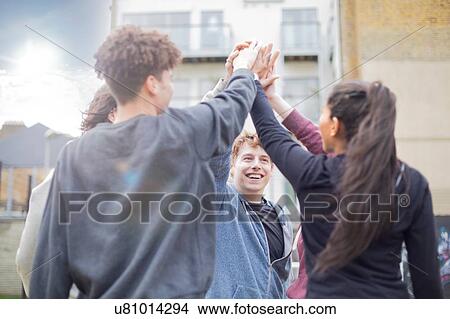 Picture - Group of adults, touching hands, outdoors. Fotosearch