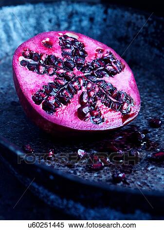 Stock Photography - Half a pomegranate on blue plate. Fotosearch