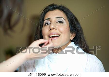 Stock Photo - Hands of female make up artist applying pin lip pencil to clients lips. Fotosearch
