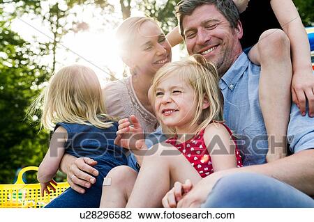 Happy parents and three daughters sharing family picnic in park View Large Photo Image Stock Image - Happy parents and three daughters sharing family picnic in park. Fotosearch