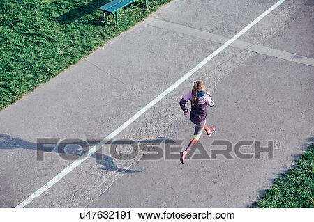 High angle view of female runner running on road View Large Photo Image Stock Image - High angle view of female runner running on road. Fotosearch