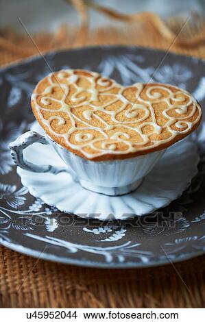 High angle view of heart shaped biscuit on top of vintage tea cup and saucer View Large Photo Image Picture - High angle view of heart shaped biscuit on top of vintage tea cup and saucer. Fotosearch