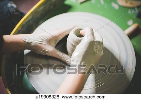 High angle view of young womans hands shaping clay on pottery wheel View Large Photo Image Stock Photo - High angle view of young womans hands shaping clay on pottery wheel. Fotosearch