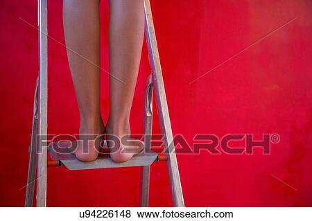 Legs and bare feet of girl on step ladder in front of red wall View Large Photo Image Stock Photo - Legs and bare feet of girl on step ladder in front of red wall. Fotosearch