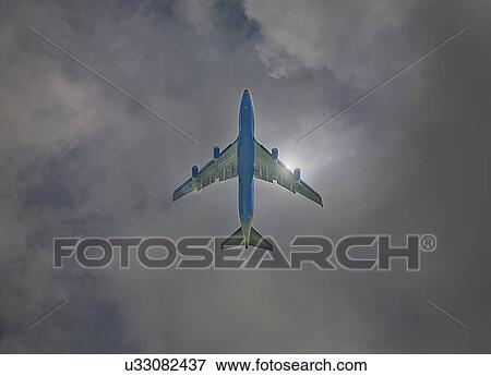 Stock Photo - Low angle view of airplane in sky. Fotosearch