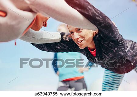 Low angle view of two female runners doing warm up exercise together View Large Photo Image Stock Photography - Low angle view of two female runners doing warm up exercise together. Fotosearch