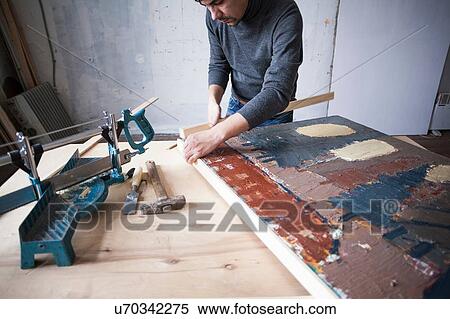 Stock Photography - Male artist, framing artwork. Fotosearch